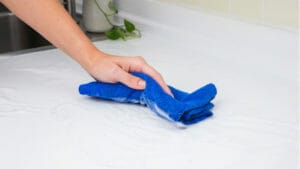 A hand cleaning a kitchen counter.